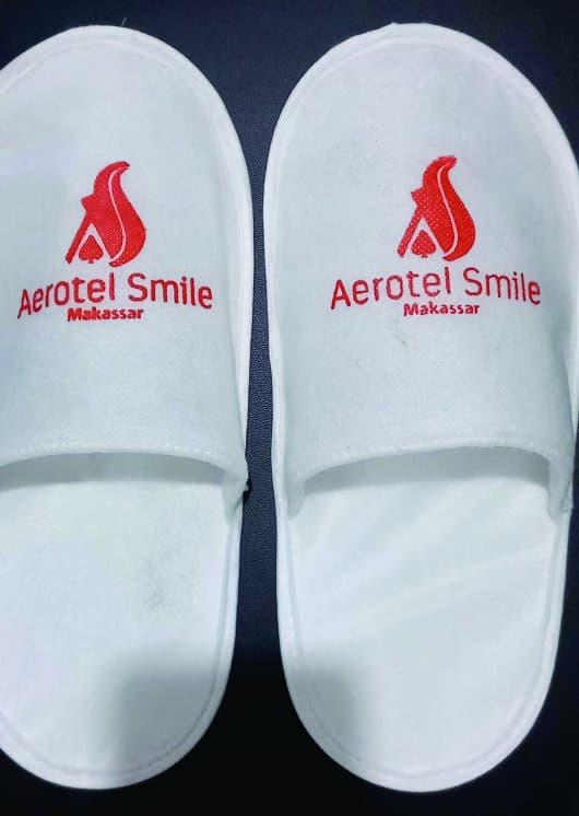 Slipper hotel putih dengan logo custom bordir merah